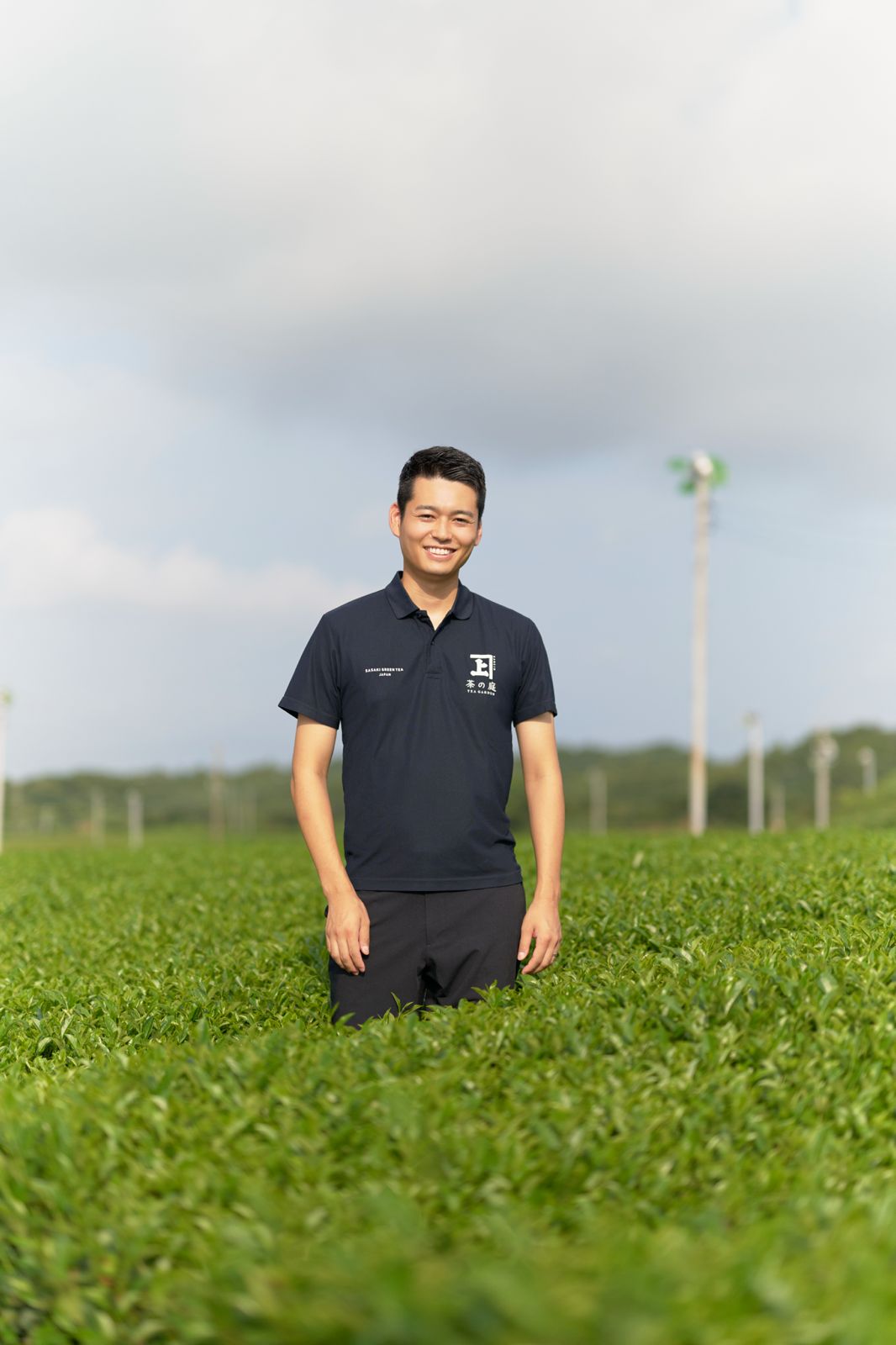 Sasaki Seicha's chief executive standing among the tea rows in Kakegawa, Shizuoka