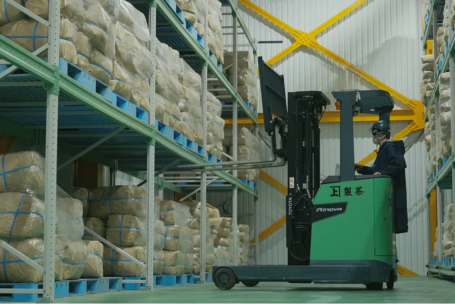 A worker operating a forklift in the Sasaki Seicha cold storage warehouse, where finished tea is held at controlled temperature and humidity.