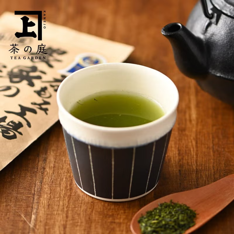 Cup of deep-steamed fukamushi sencha with a cast-iron teapot and loose leaves
